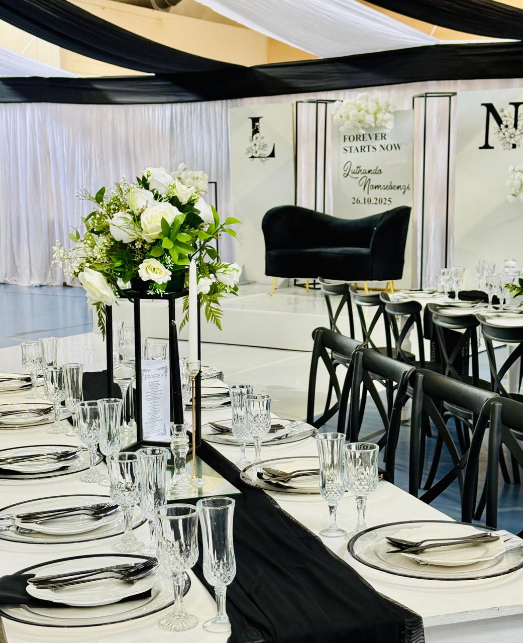 Black and white table setting with white rose centrepiece