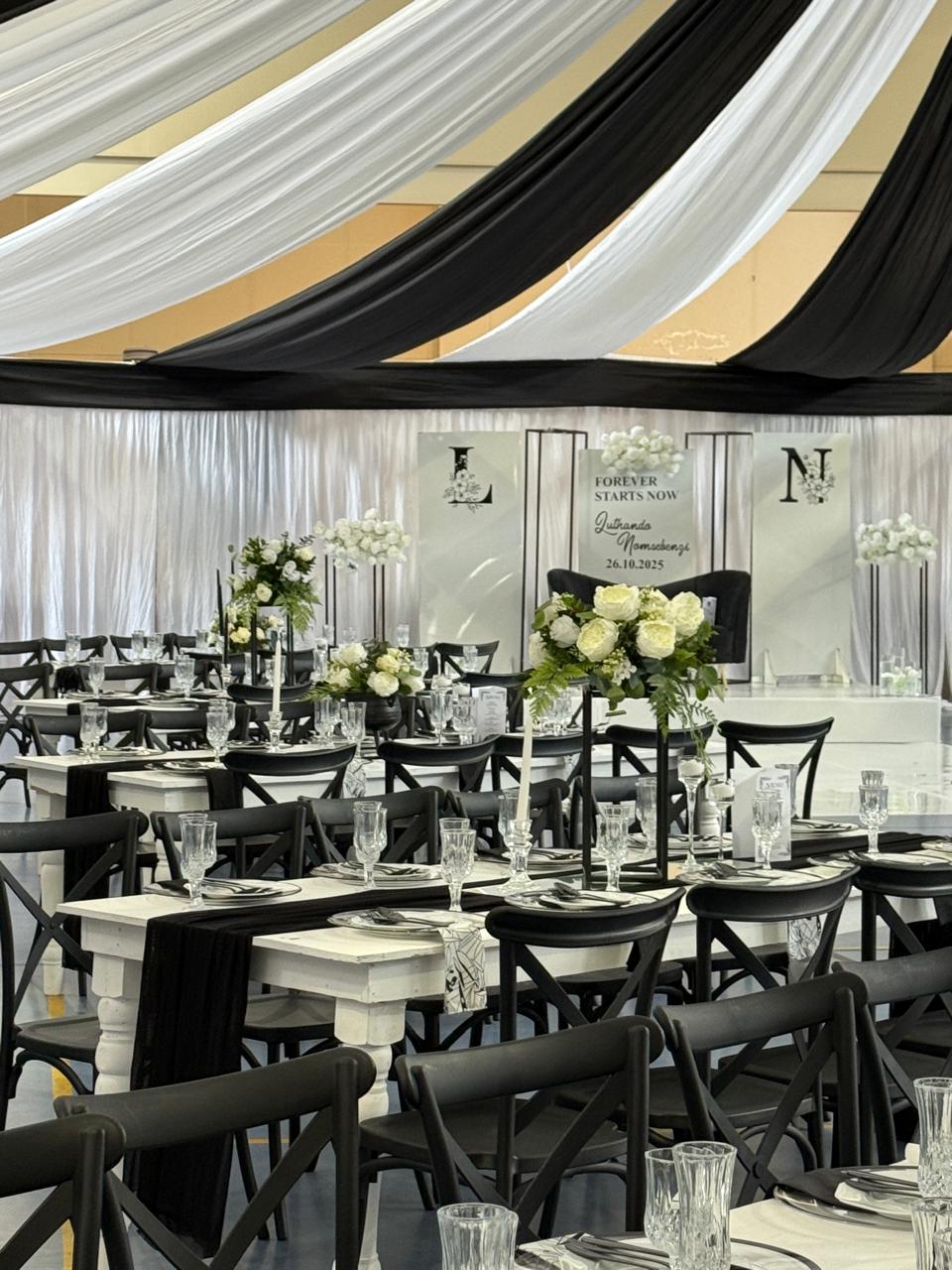 Black, white and gold ceiling draping over banquet tables