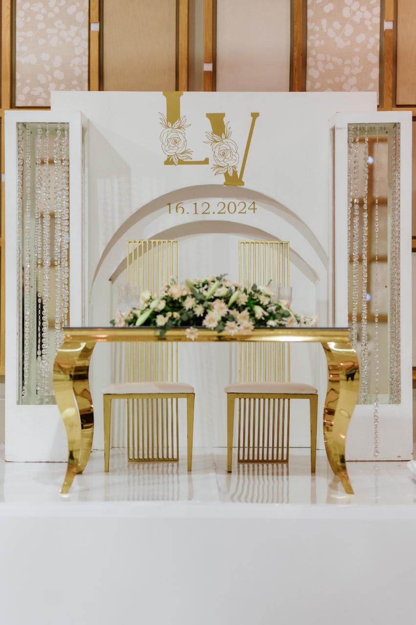 Gold and white wedding top table with monogram backdrop and crystal draping