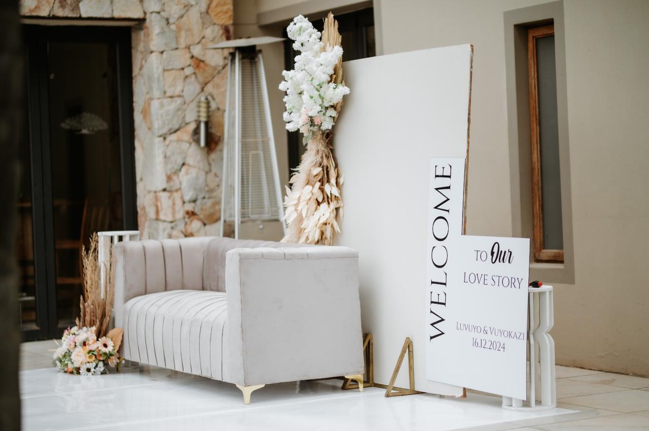 Welcome to our love story sign with blush velvet couch and pampas florals